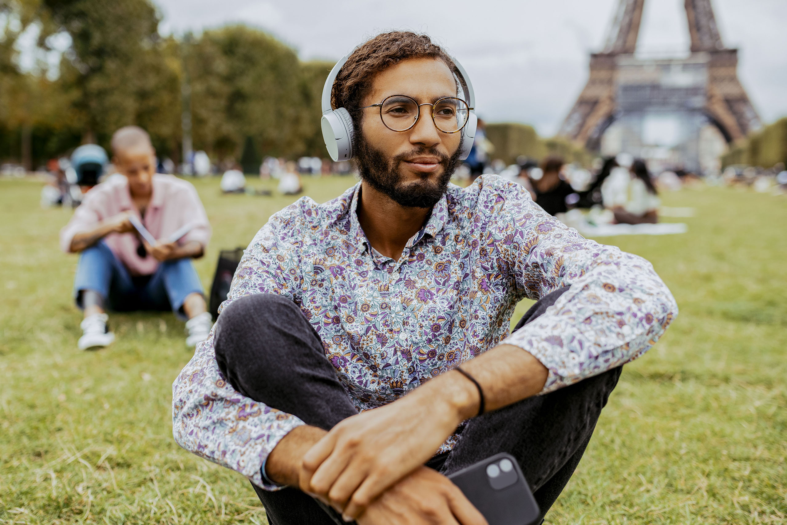 Handsome mixed race man looking at camera and listening to music on wireless headphones