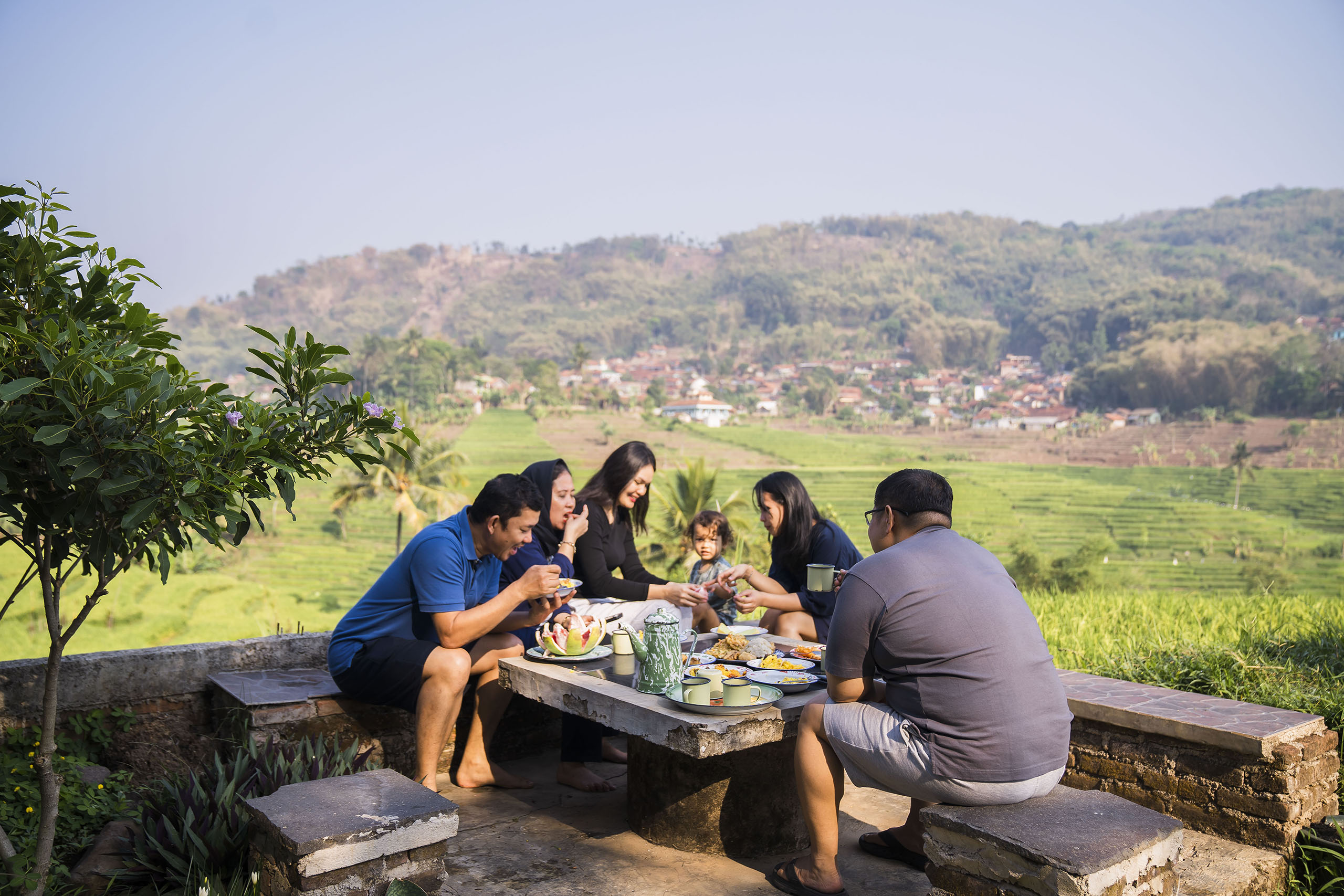 Multi generation asian family are having breakfast at garden table